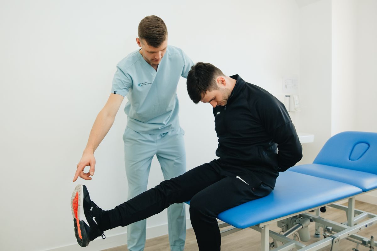 Kinésithérapeute étirant la jambe d’un patient allongé
