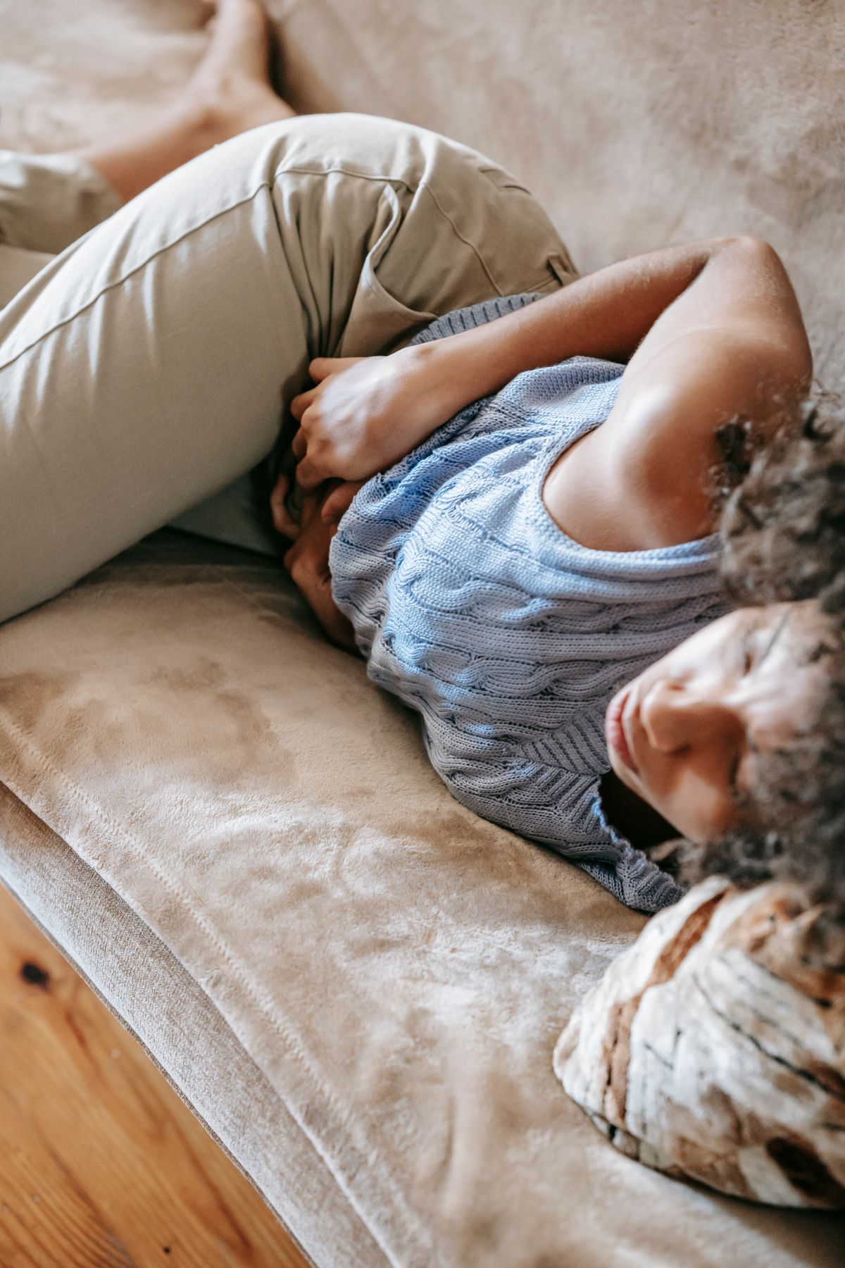 Femme allongée se tenant le ventre, inconfort digestif